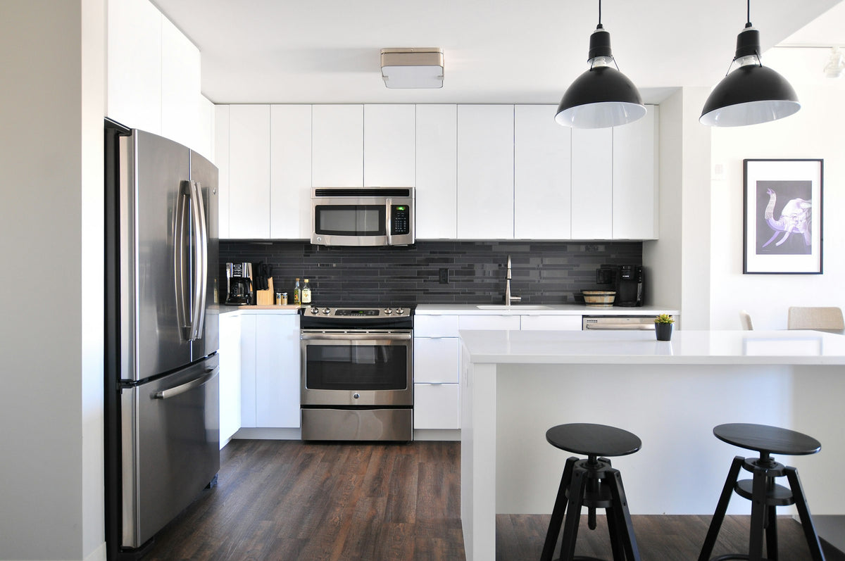Modular kitchen with grey cabinets and a steel refrigerator