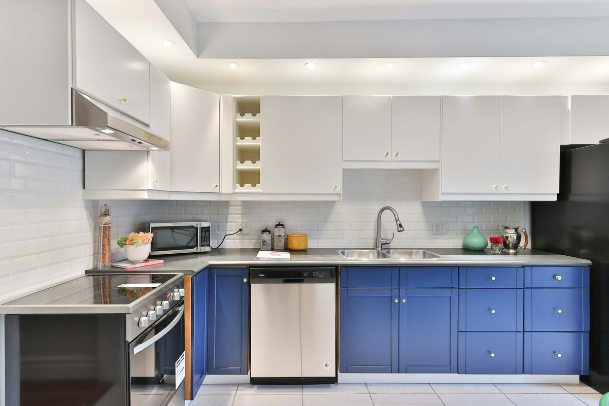 Kitchen with blue cabinets and a black refrigerator