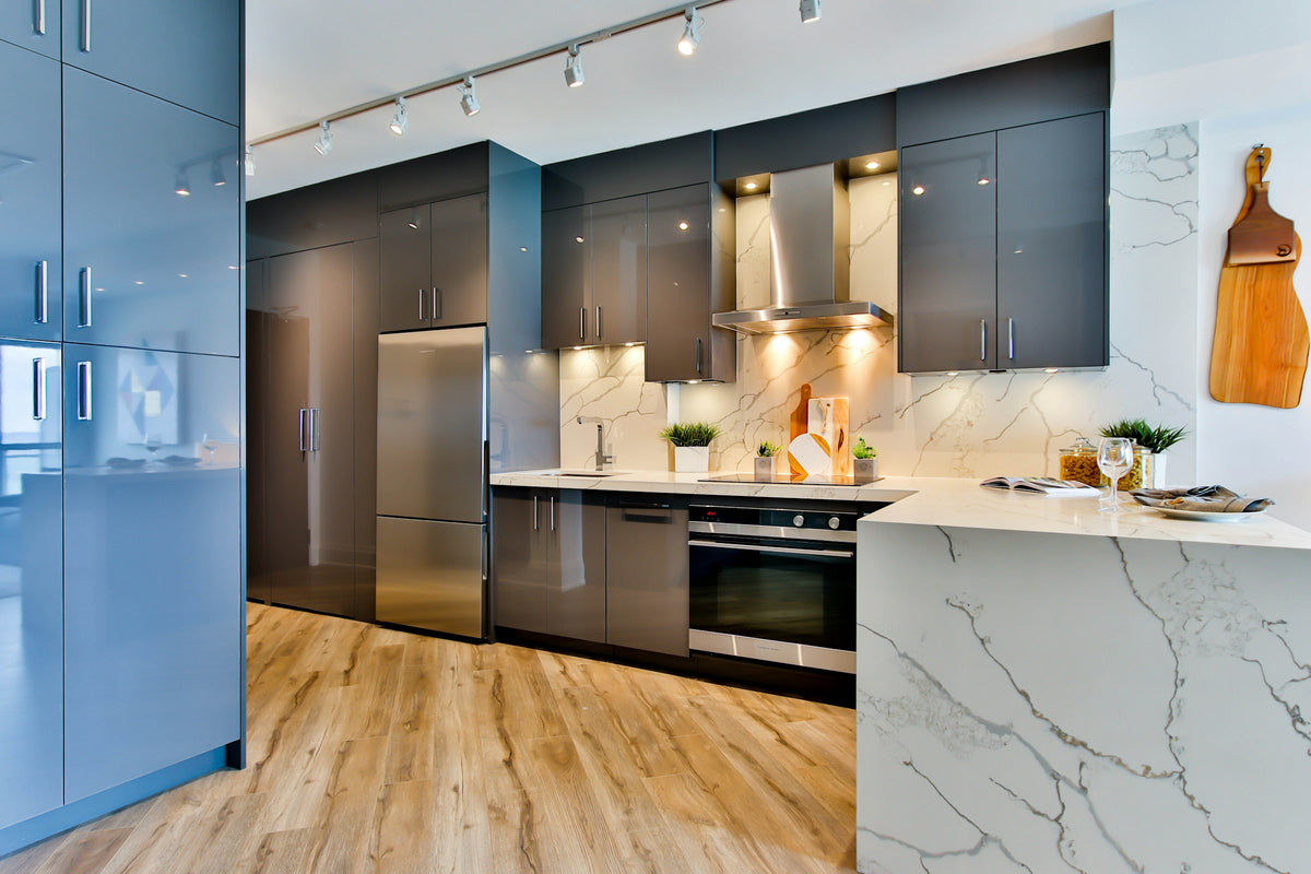 Kitchen with grey cabinets, marble countertops and light wood flooring