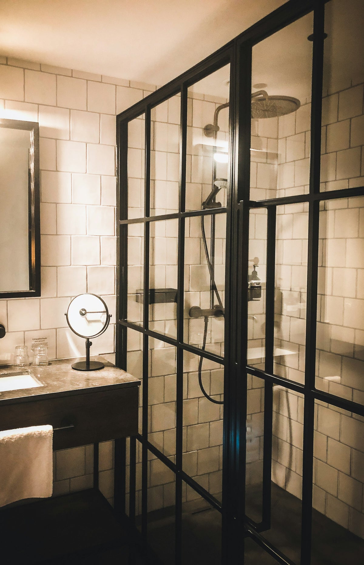 Sink beside a black-framed glass shower