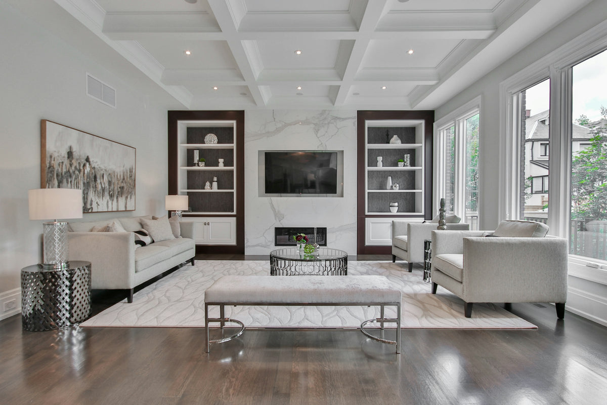 Living room with a marble fireplace, white sofas and dark wood shelving