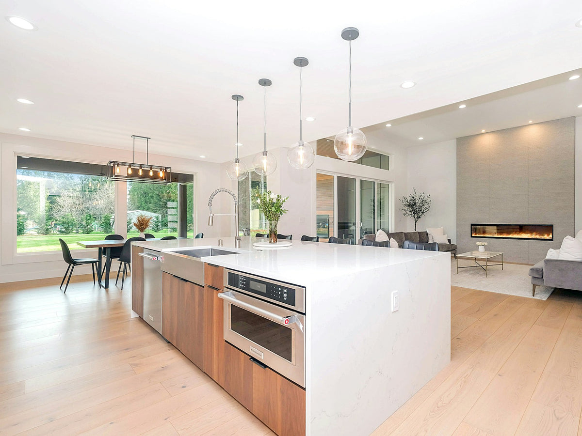 Open kitchen with white and wood cabinetry flowing into the living room
