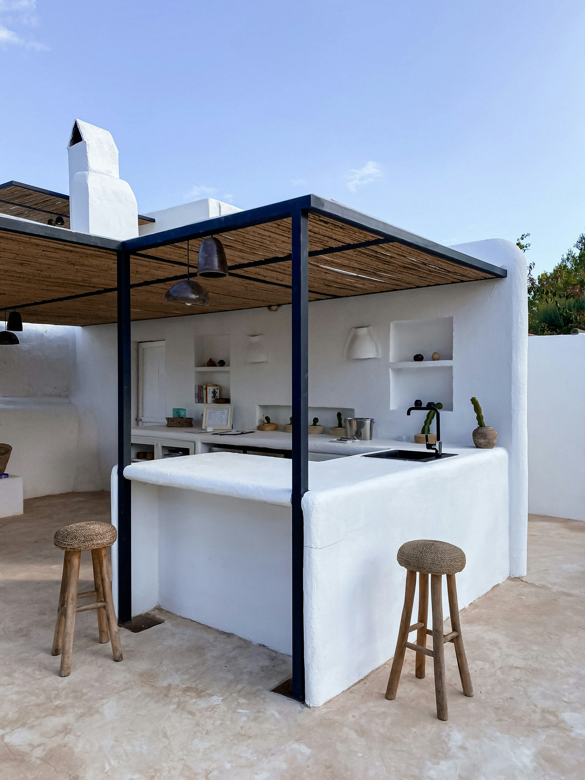 Outdoor kitchen with a bar and stools