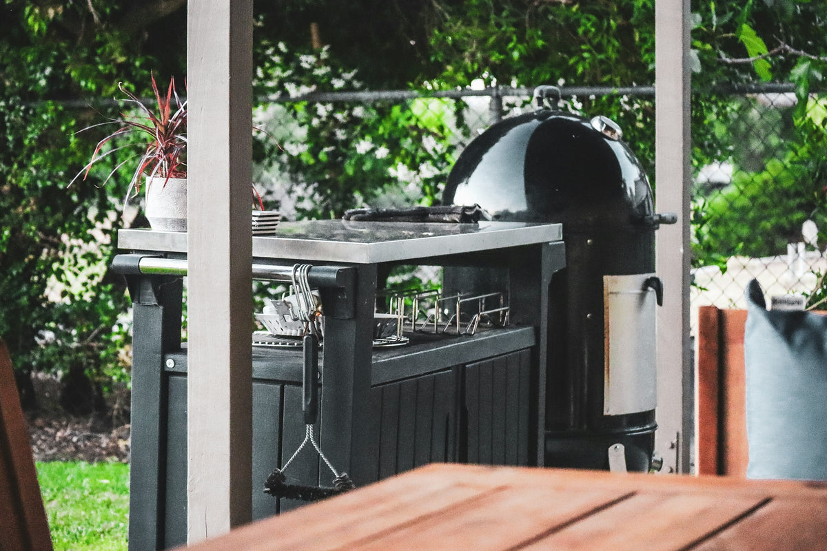 Outdoor grill surrounded by plants
