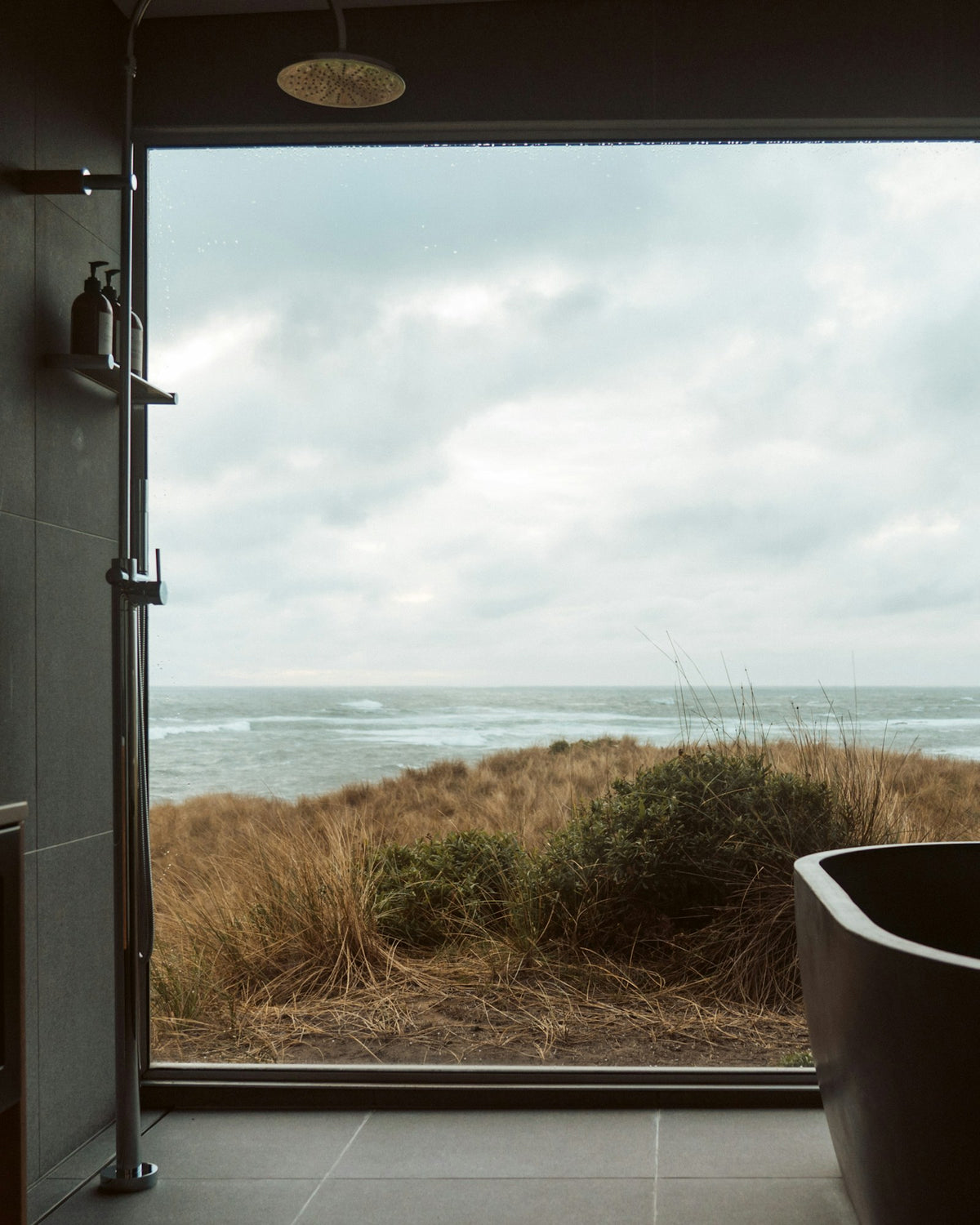 Freestanding soaking tub beside a large window