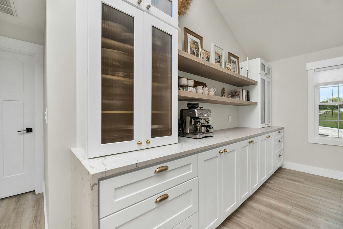 White kitchen with wood floors and brass details
