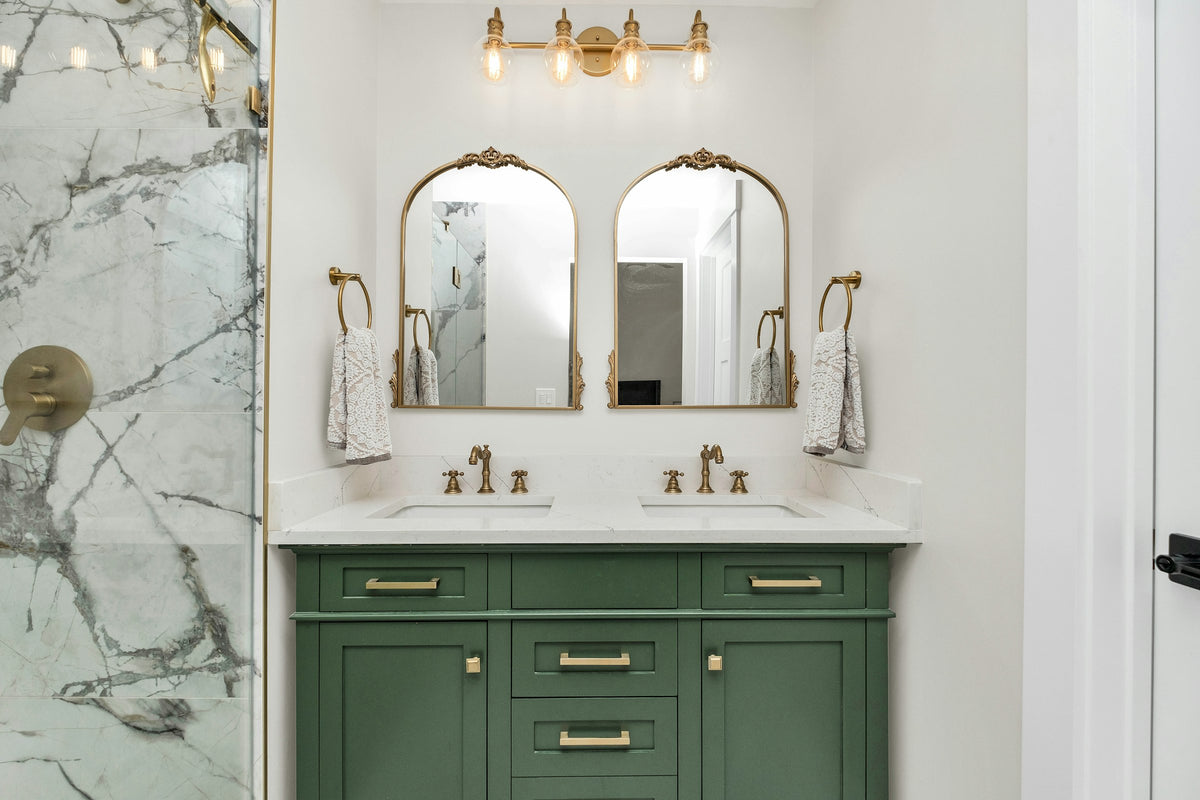 Bathroom with marble counters and green vanity cabinets