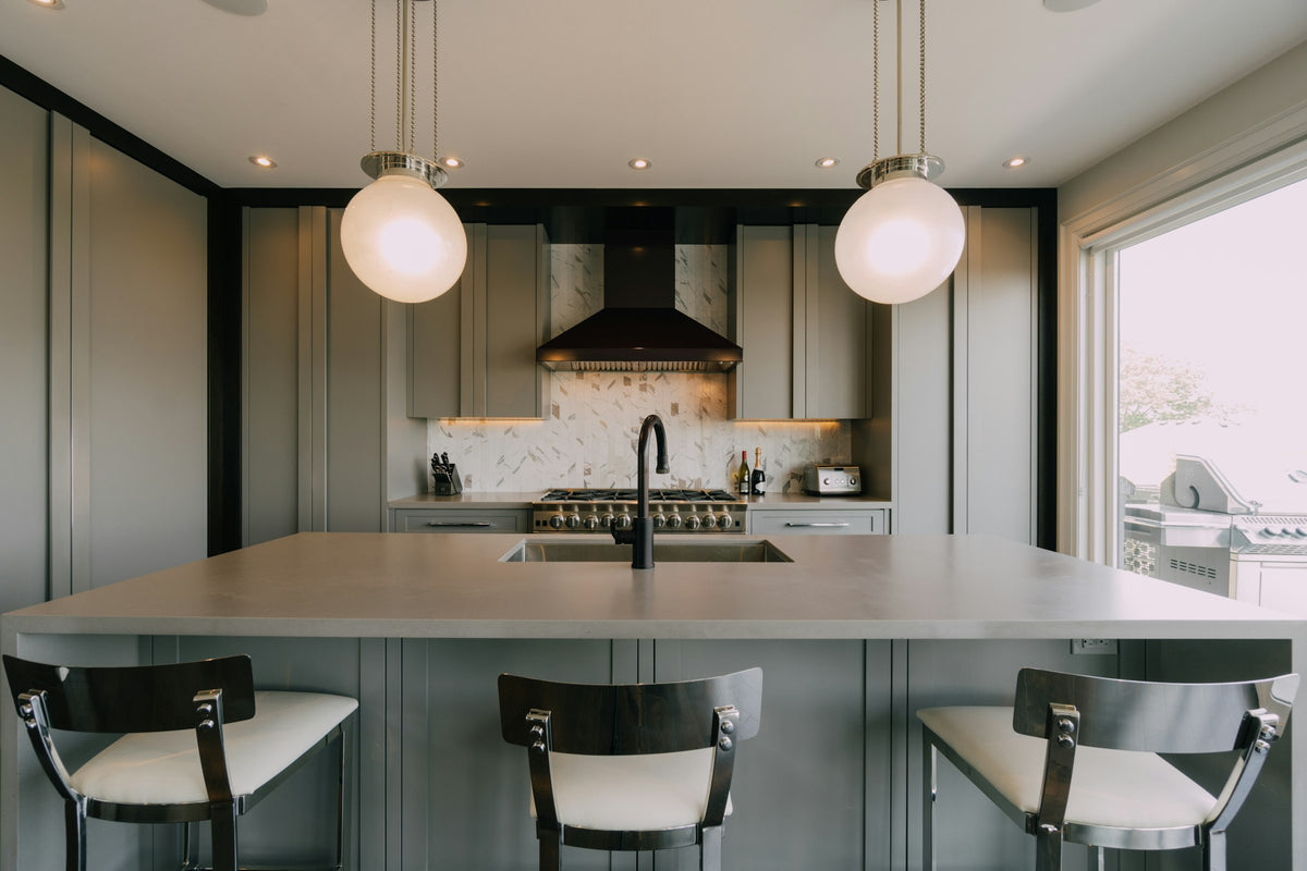 Kitchen with a marble center island and three chairs