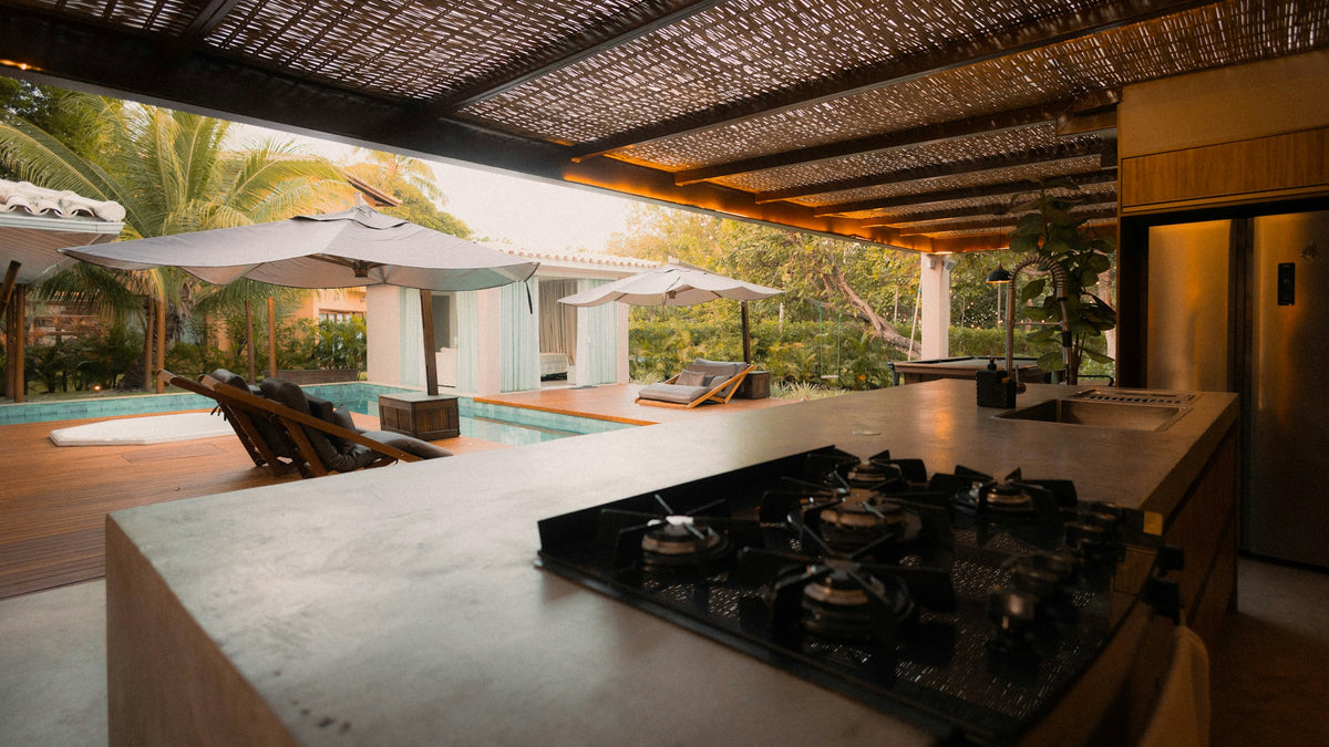 Outdoor kitchen beside a pool at sunset