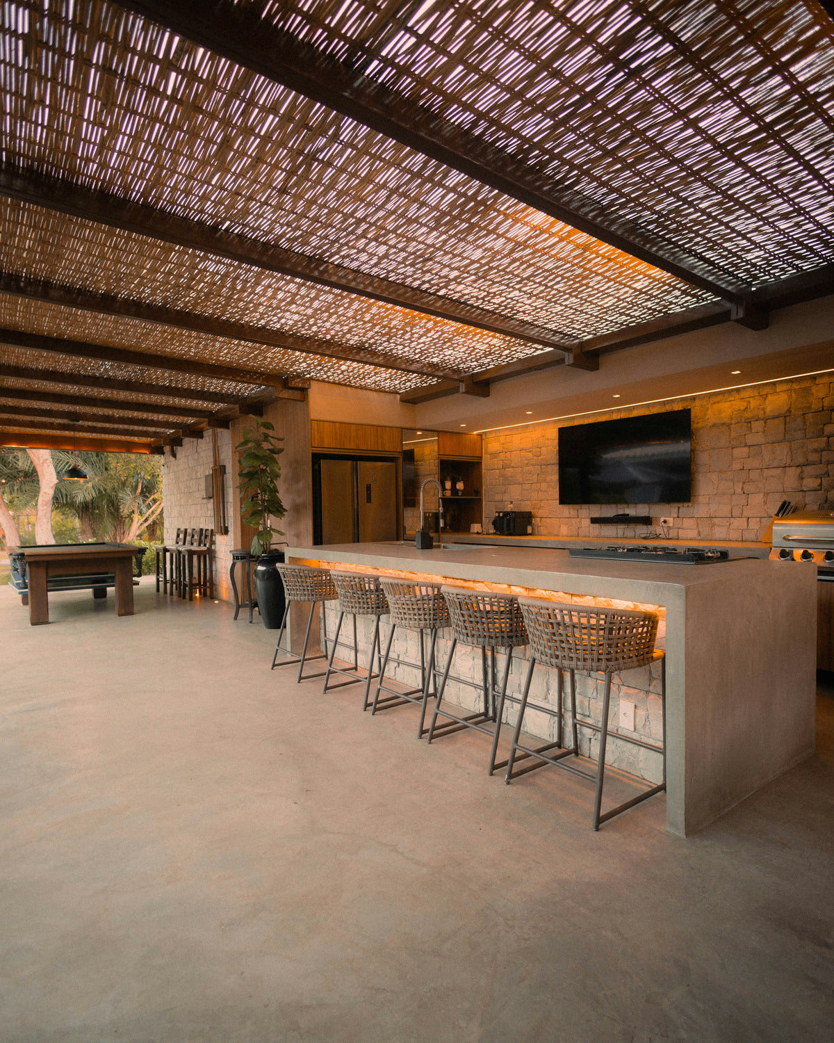 Outdoor kitchen with an island and bar stools