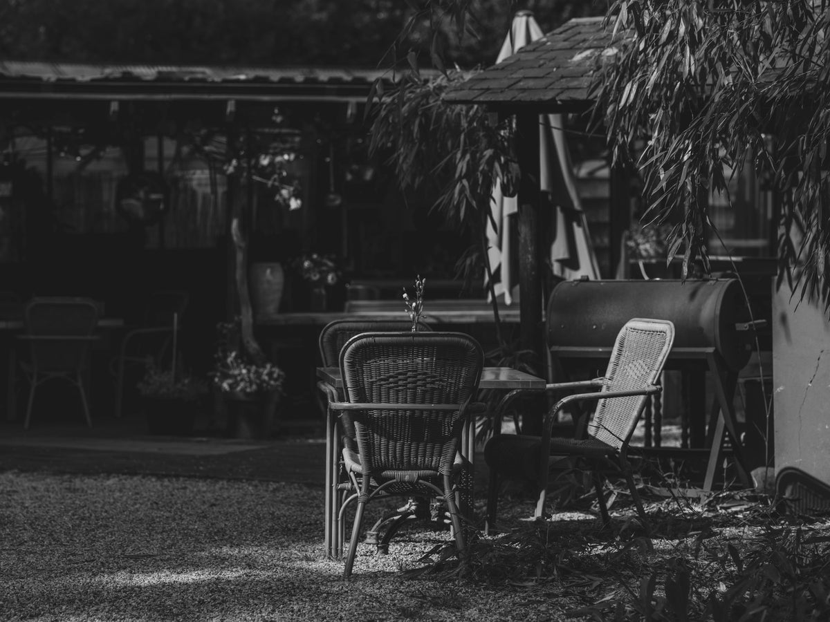 Black and white outdoor patio with dining table and grill